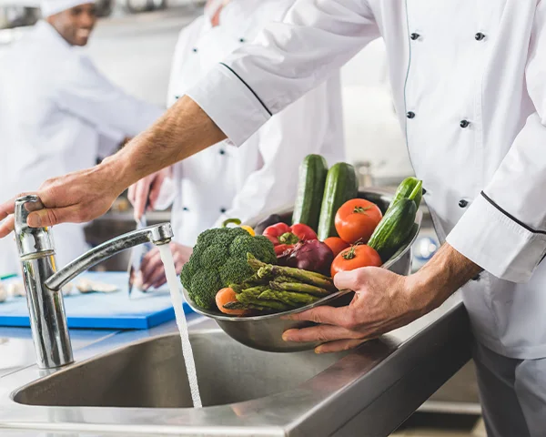 A chef washing vegetables