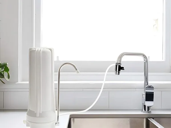 A countertop water purifier connected to a faucet placed on the countertop