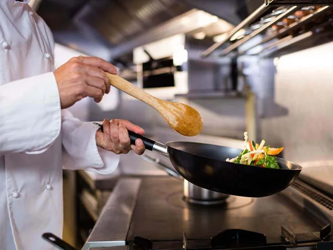 A person cooking with a frying pan and spatula