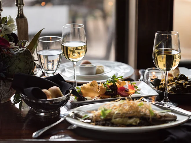 Many drinks and dishes placed on the table.