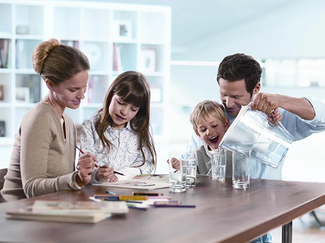 Mother and daughter are painting, father is hugging son and pouring water.