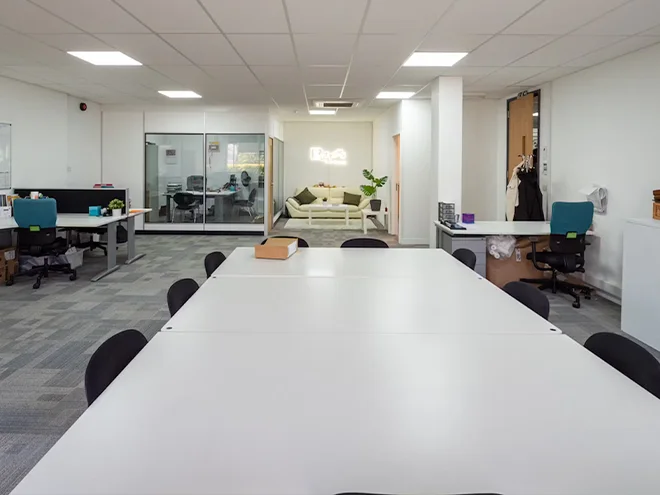 Many office desks and chairs placed in an office