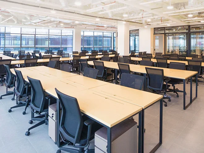 Many office desks and chairs neatly arranged in the office.