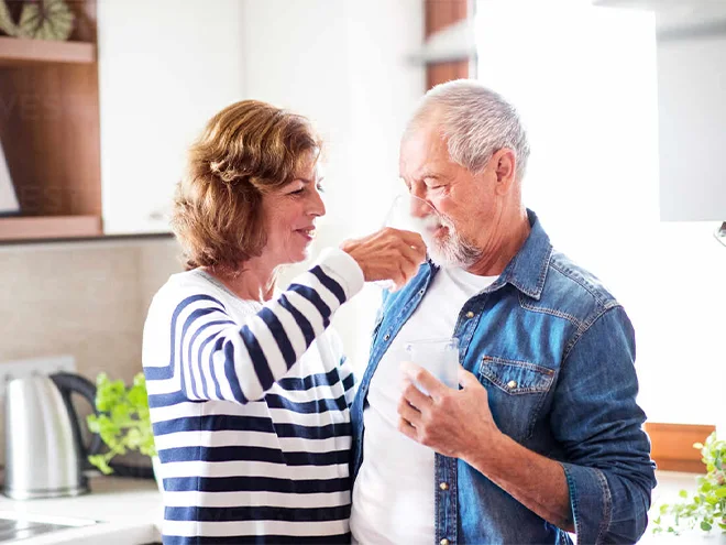 A wife is feeding her husband water.