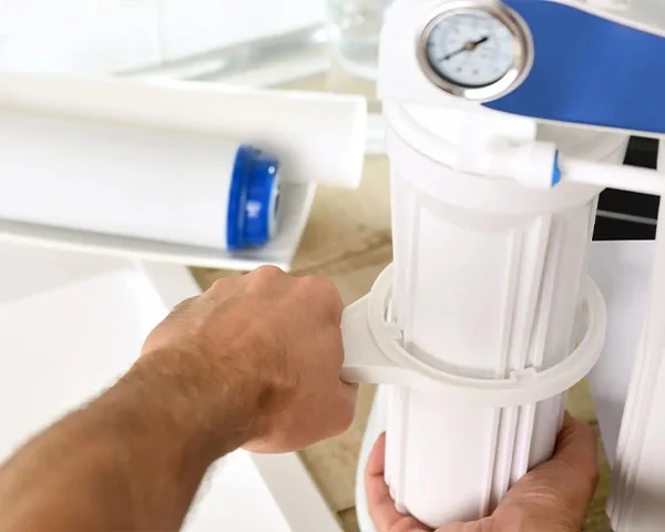 A person installing an RO water purifier with a wrench