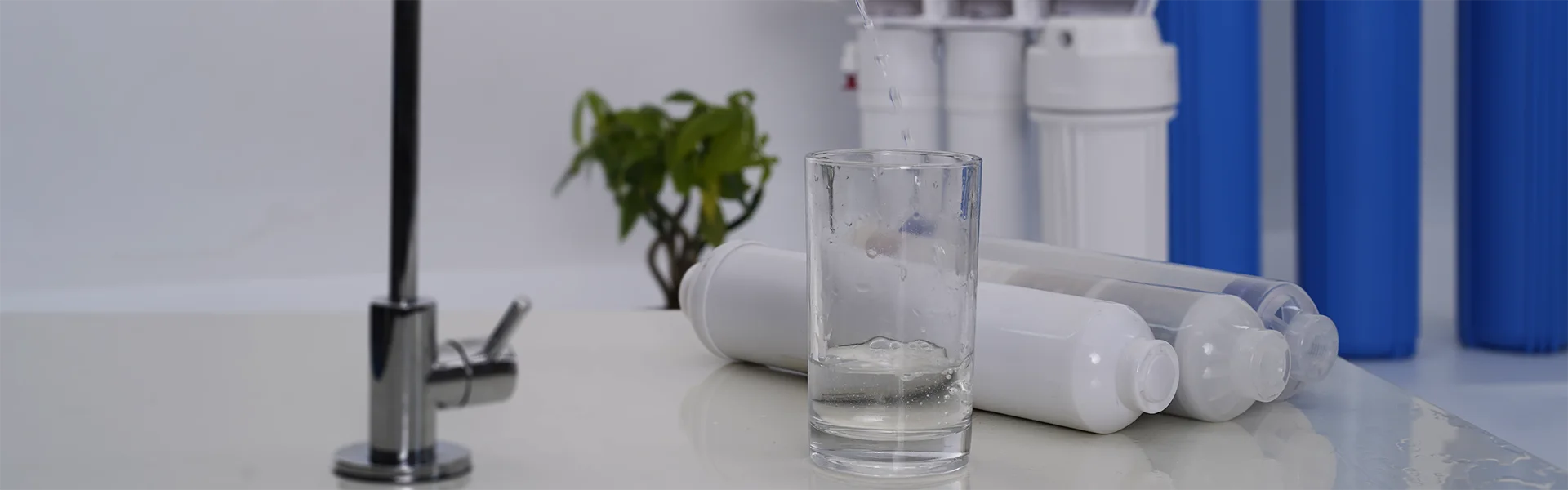 A glass of water and some water purifier components are placed on the table.