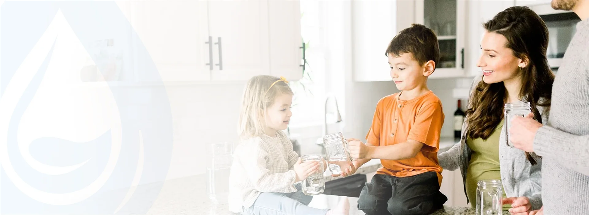 Parents hold water glasses, smiling at their children toasting on the table.